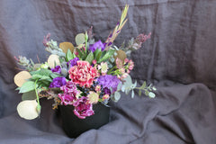 Celebratory and sophisticated palette including purple lisianthus, antique carnation, purple parrot tulips, and a hint of gold eucalyptus.