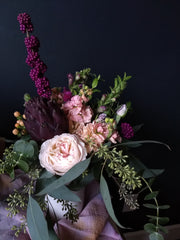 Moody, romantic arrangement featuring garden rose, purple artichoke, beautyberry, scented stock and eucalyptus.
