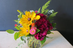 Summery bouquet featuring local flowers like rudebeckia, celosia, strawflower and sweet annie.